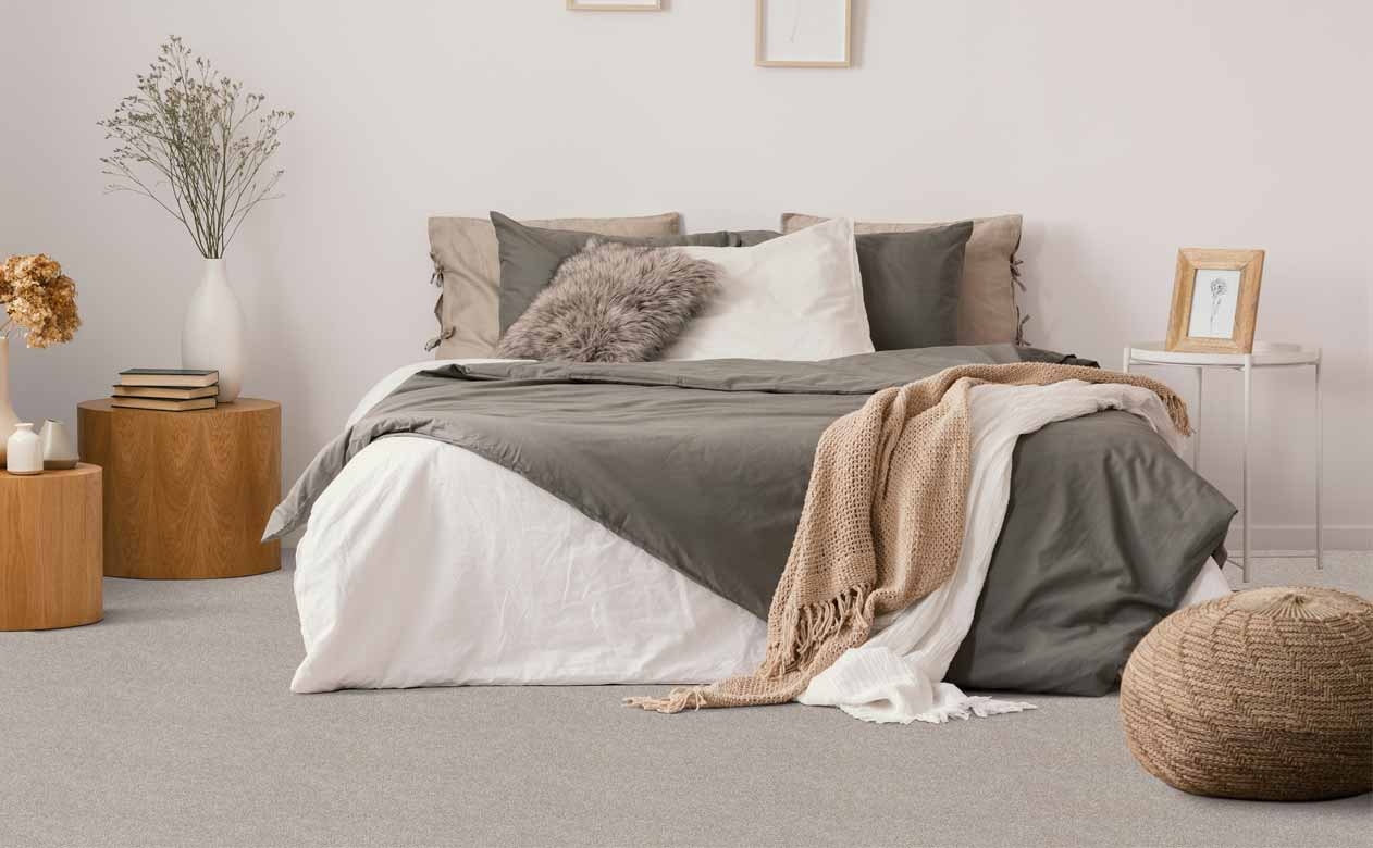 neutral colored bedroom with wood tables and grey carpet