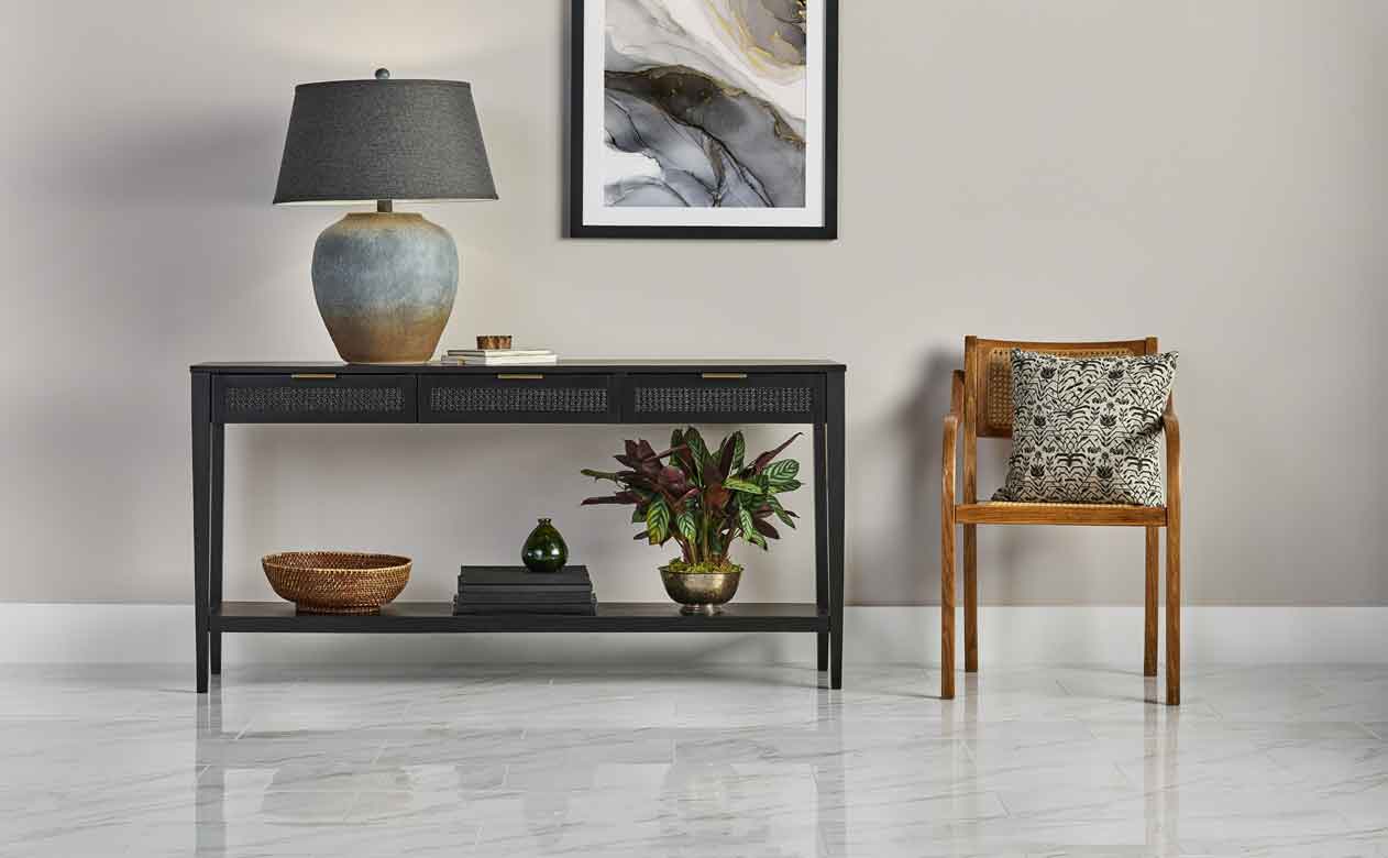 Grey tile flooring in a hallway with a wood chair and a black table